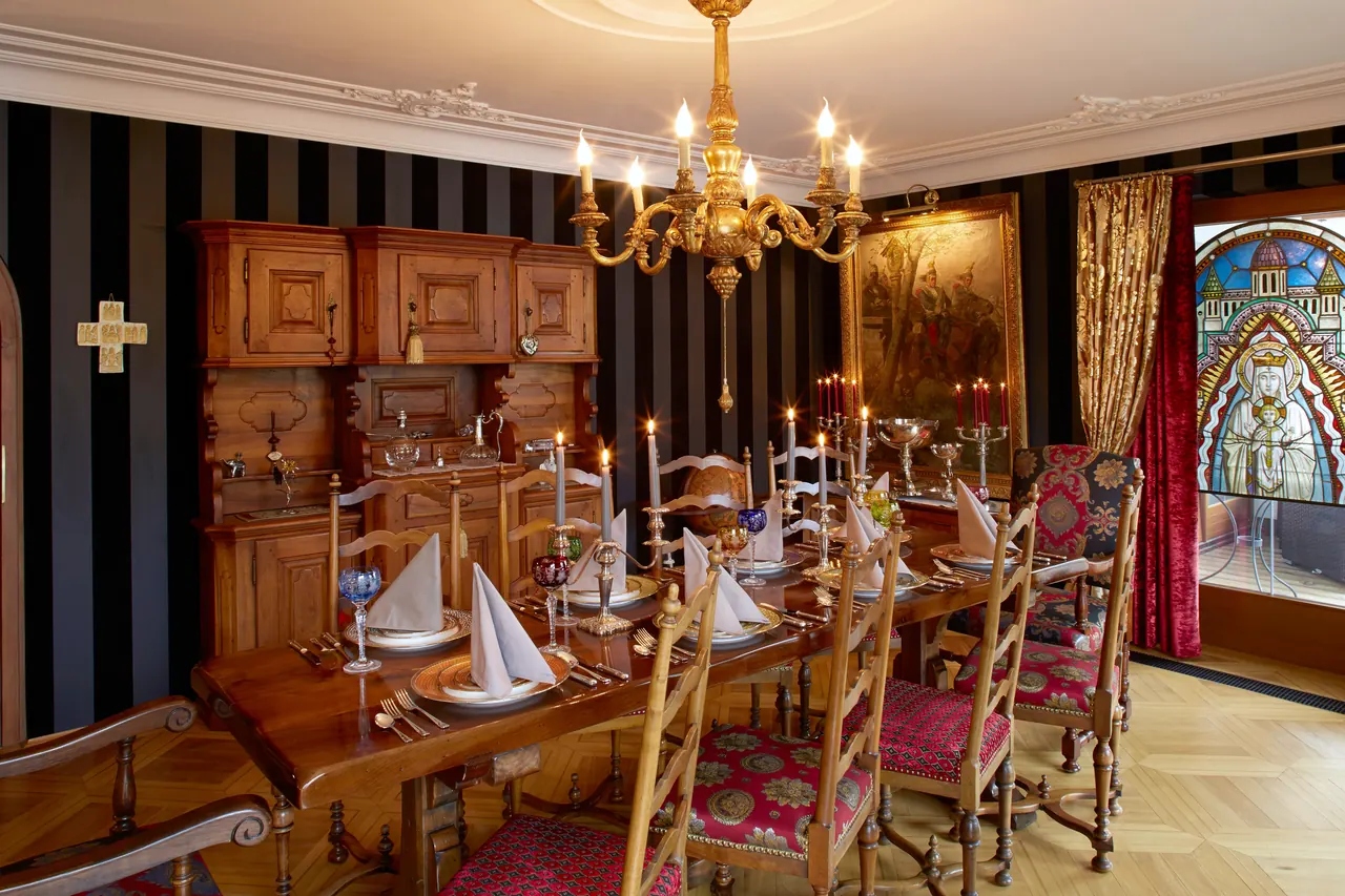 Der festlich gedeckte Dining Room im Sunneschlössli mit Kronleuchter, Kerzen, farbigen Weingläsern und dem Bleiglasfenster