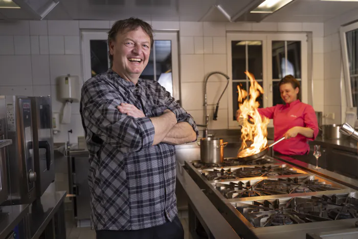 Host Christian in the kitchen of the Landgasthof Schuster, his daughter Bella cooking behind him