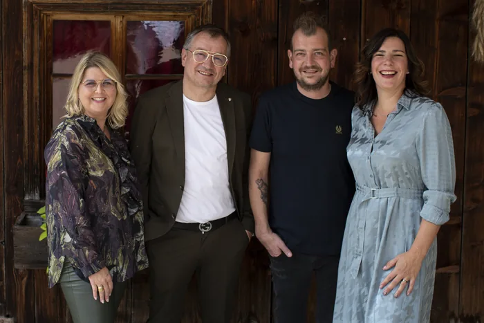 Die Gastgeberfamilie des Sonnenhofs in Grän vor der alten Holztür des Hauses