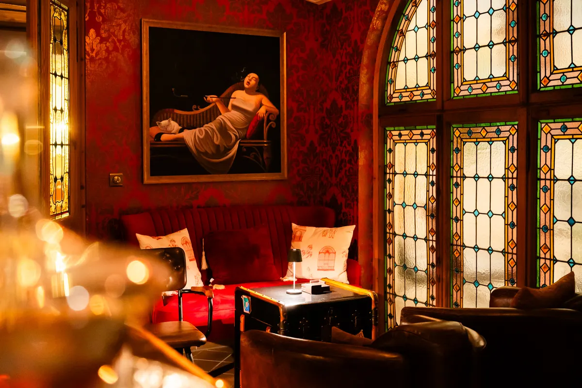 Seating corner of the Orient Express bar with a painting and stained-glass window