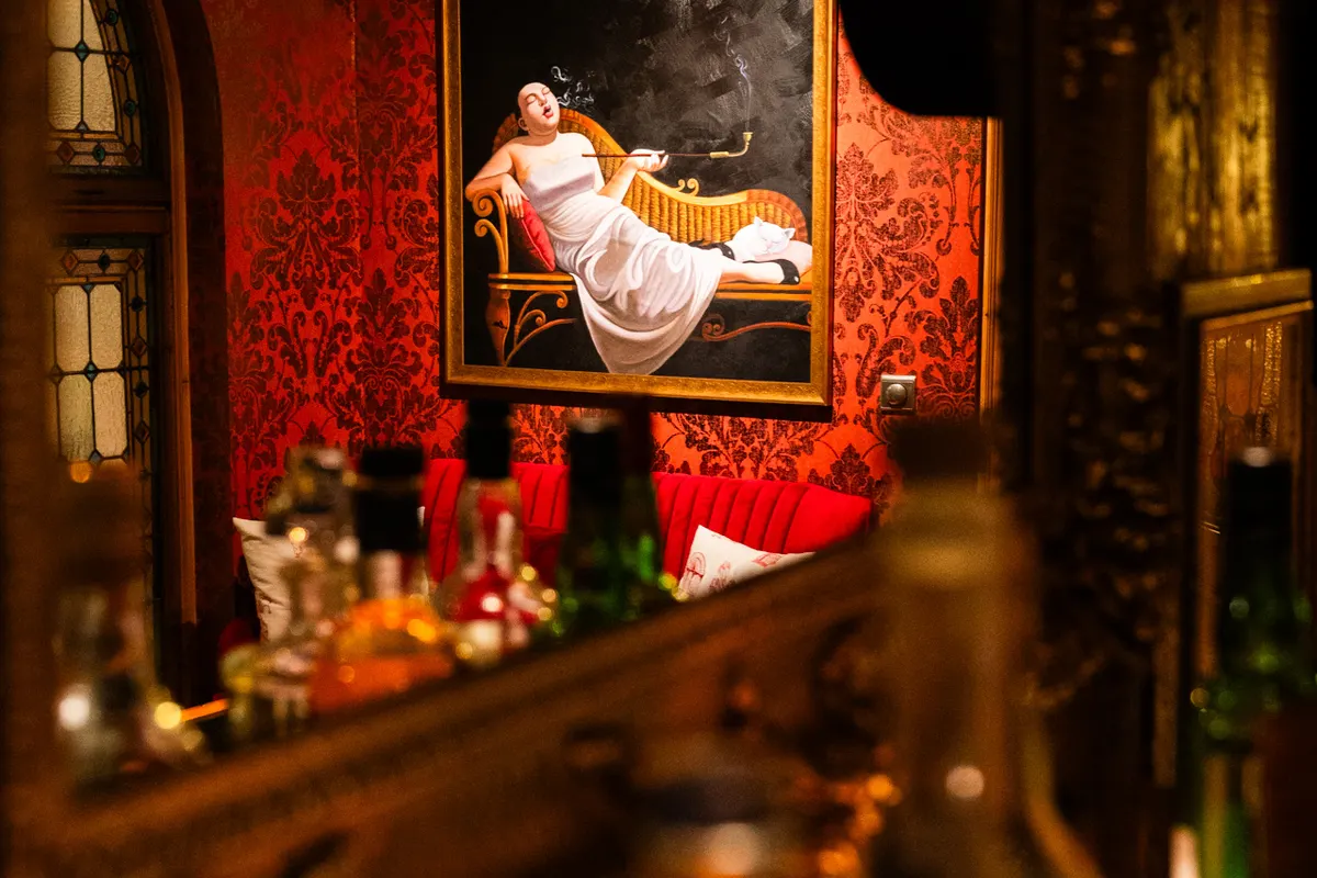 The painting above the bar, bottles in warm light