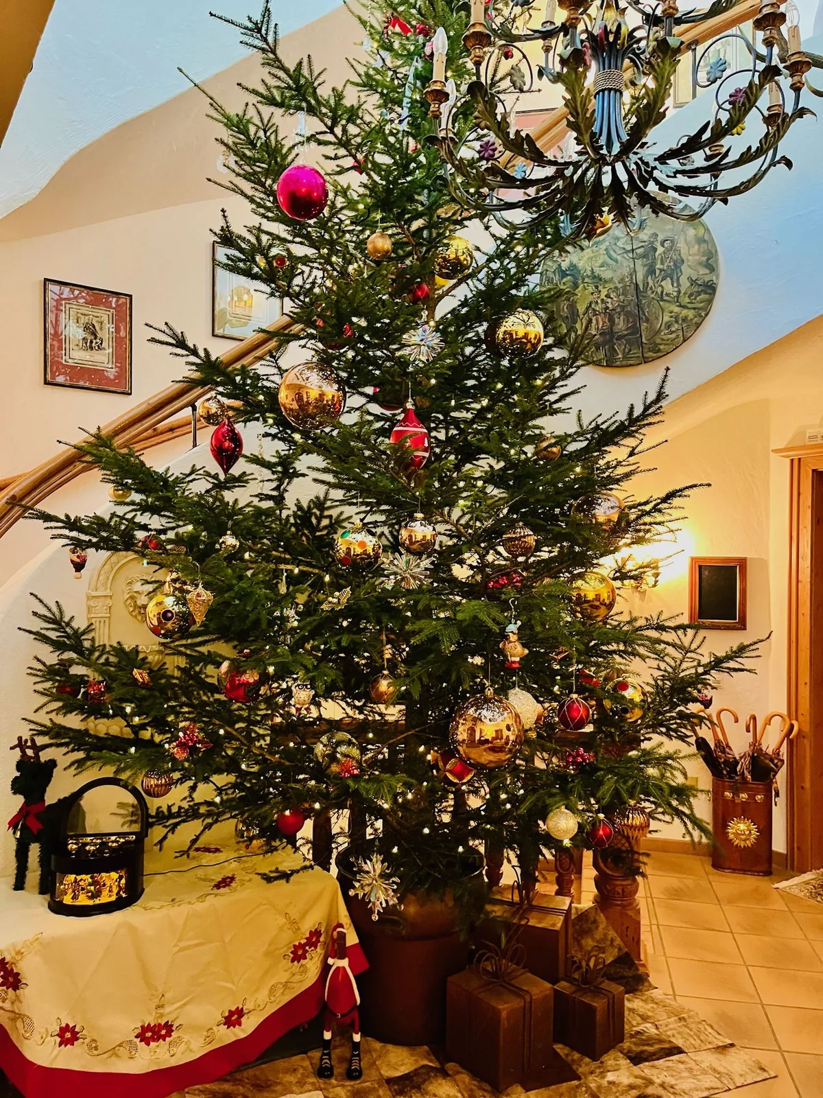 Der geschmückte Christbaum im Eingang des Sunneschlössli, darüber der Geweihluster